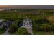 Aerial view of a charming two-story home with balconies and a well-manicured yard amidst lush greenery at 1720 Mariner Way, Tarpon Springs, FL 34689