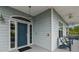 Charming front entrance with blue door, coastal details, and a welcoming porch with seating area at 1720 Mariner Way, Tarpon Springs, FL 34689