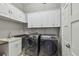 Functional laundry room boasts built-in cabinets, sink, and modern washer and dryer units at 1720 Mariner Way, Tarpon Springs, FL 34689