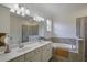 Well-lit bathroom with double sink vanity, soaking tub, and glass-enclosed shower at 17541 Timberline Pkwy, Punta Gorda, FL 33982