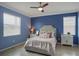 Cozy bedroom with a ceiling fan, two windows, side tables with lamps and neutral furnishings at 17541 Timberline Pkwy, Punta Gorda, FL 33982