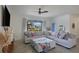Bright living room featuring a large sectional sofa, ceiling fan, and expansive windows with backyard views at 17541 Timberline Pkwy, Punta Gorda, FL 33982