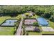 Aerial view of tennis courts, a pond, mature trees, and lush green space at 17927 Bahama Isle Cir, Tampa, FL 33647