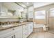 Well-lit bathroom featuring granite counters, soaking tub, and a separate glass shower at 17927 Bahama Isle Cir, Tampa, FL 33647