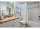 Bathroom featuring granite counters, a shower-tub combo with white tile, and bright natural light at 17927 Bahama Isle Cir, Tampa, FL 33647