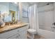 Bathroom featuring granite counters, tiled shower and white fixtures at 17927 Bahama Isle Cir, Tampa, FL 33647