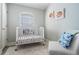 Bright Bedroom with a white crib, chair and charming decor at 17927 Bahama Isle Cir, Tampa, FL 33647