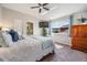 Bright main bedroom featuring a ceiling fan, television, and an ensuite bathroom at 17927 Bahama Isle Cir, Tampa, FL 33647