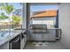 Outdoor kitchen featuring stainless steel grill, granite countertop, sink, and cabinets at 17927 Bahama Isle Cir, Tampa, FL 33647