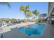 Gorgeous pool featuring a lake view, palm trees, and an outdoor seating area at 17927 Bahama Isle Cir, Tampa, FL 33647