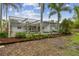 View of the backyard, screened in pool, and tropical landscaping at 1870 Wateroak W Dr, Clearwater, FL 33764