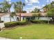 Charming single-story home with a well-manicured lawn and tropical landscaping at 1870 Wateroak W Dr, Clearwater, FL 33764