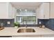 Kitchen sink view featuring stainless steel sink, stylish backsplash and pool at 1870 Wateroak W Dr, Clearwater, FL 33764