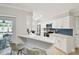 Bright kitchen with white cabinets, stainless steel appliances, breakfast bar and view to dining area at 1870 Wateroak W Dr, Clearwater, FL 33764
