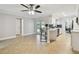 Open-concept living space with tile flooring, fan, and view of updated kitchen and access to backyard at 1870 Wateroak W Dr, Clearwater, FL 33764