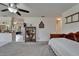 Bedroom showcasing a ceiling fan, an antique bookcase, and access to the kitchen at 1929 New Bedford Dr, Sun City Center, FL 33573