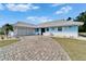 Charming blue single-story home with a brick driveway and well-maintained landscaping at 1929 New Bedford Dr, Sun City Center, FL 33573
