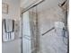 Shower with glass door, handrails, marble wall, and toiletries at 1929 New Bedford Dr, Sun City Center, FL 33573