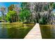 A serene view of the lake from the end of a backyard dock at 20926 Ragan Ln, Land O Lakes, FL 34638