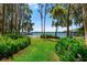 Beautiful view of the tranquil lake from the lush green backyard, framed by trees at 20926 Ragan Ln, Land O Lakes, FL 34638