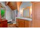 Well-lit bathroom featuring wooden cabinets, unique clawfoot tub, and a window with serene natural views at 20926 Ragan Ln, Land O Lakes, FL 34638