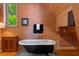 Bathroom with wood paneling, a clawfoot tub, and natural light from the window at 20926 Ragan Ln, Land O Lakes, FL 34638