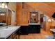 Rustic wood bathroom with dual vanity, black cabinets, modern fixtures, and a soaking tub at 20926 Ragan Ln, Land O Lakes, FL 34638
