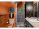 Bathroom featuring a tiled shower, wood paneling, vanity, and modern toilet at 20926 Ragan Ln, Land O Lakes, FL 34638