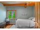 Cozy bedroom featuring hardwood floors, a window with green views, and natural light at 20926 Ragan Ln, Land O Lakes, FL 34638