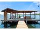 Covered boat dock with lift, storage area, and space for relaxing by the water's edge at 20926 Ragan Ln, Land O Lakes, FL 34638