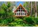 Charming A-frame home with walls of windows, wood deck, stone chimney, and lush landscaping at 20926 Ragan Ln, Land O Lakes, FL 34638