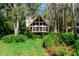 A-frame home featuring large windows, a stone chimney, and lush landscaping at 20926 Ragan Ln, Land O Lakes, FL 34638