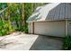 Detached garage with an updated metal roof and surrounded by mature trees offering parking and storage at 20926 Ragan Ln, Land O Lakes, FL 34638