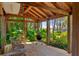View of covered deck with outdoor furniture and lake view. Enjoy nature from the comfort of this wooded lot at 20926 Ragan Ln, Land O Lakes, FL 34638