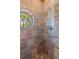 Close up of tiled shower with a unique circle window offering outdoor views at 20926 Ragan Ln, Land O Lakes, FL 34638