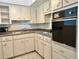 Vintage kitchen featuring white cabinets, stainless steel sink and black appliances at 2100 World Parkway Blvd # 50, Clearwater, FL 33763