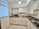 Bright vintage kitchen with microwave, stainless steel sink and white cabinets at 2100 World Parkway Blvd # 50, Clearwater, FL 33763