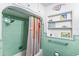 Bathroom showcasing vintage green tile, colorful shower curtain, and built-in shelving at 2217 Brevard Ne Rd, St Petersburg, FL 33704