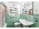 Retro bathroom with green tile, vintage fixtures, and unique shelving at 2217 Brevard Ne Rd, St Petersburg, FL 33704