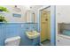 Charming blue bathroom featuring vintage fixtures, unique wall art, and a classic shower at 2217 Brevard Ne Rd, St Petersburg, FL 33704