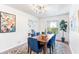 Bright dining room with a modern light fixture, a dark wood table with blue chairs, and an elegant area rug at 2217 Brevard Ne Rd, St Petersburg, FL 33704