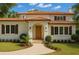 Inviting two-story home featuring a red tile roof, arched entryway, and manicured lawn with tasteful landscaping at 2217 Brevard Ne Rd, St Petersburg, FL 33704