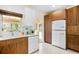 Sunlit kitchen with wooden cabinets, white appliances, tile flooring, and convenient patio access at 2217 Brevard Ne Rd, St Petersburg, FL 33704