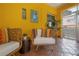 Cozy sunroom with bright yellow walls, wicker furniture, and tile flooring at 2217 Brevard Ne Rd, St Petersburg, FL 33704