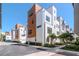 Modern townhomes with white and wood exteriors and well-maintained landscaping under a clear blue sky at 2511 N Grady Ave # 52, Tampa, FL 33607