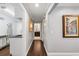 Hallway showcasing wood flooring and framed art leading to the laundry room and bathroom at 2648 Countryclub Dr, Clearwater, FL 33761