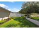 Well-manicured yard featuring a white fence and a variety of trees and plants at 2648 Countryclub Dr, Clearwater, FL 33761