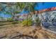 Exterior of townhouse showing backyard with mature landscaping, privacy fence and shade trees at 2700 Bayshore Blvd # 1E, Dunedin, FL 34698