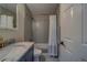 Stylish bathroom featuring a gray tiled shower, gold fixtures, and a vanity with marble countertop at 2700 Bayshore Blvd # 1E, Dunedin, FL 34698