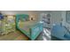 Bright bedroom featuring a blue bed frame, wood floors, and a sunny window at 2700 Bayshore Blvd # 1E, Dunedin, FL 34698